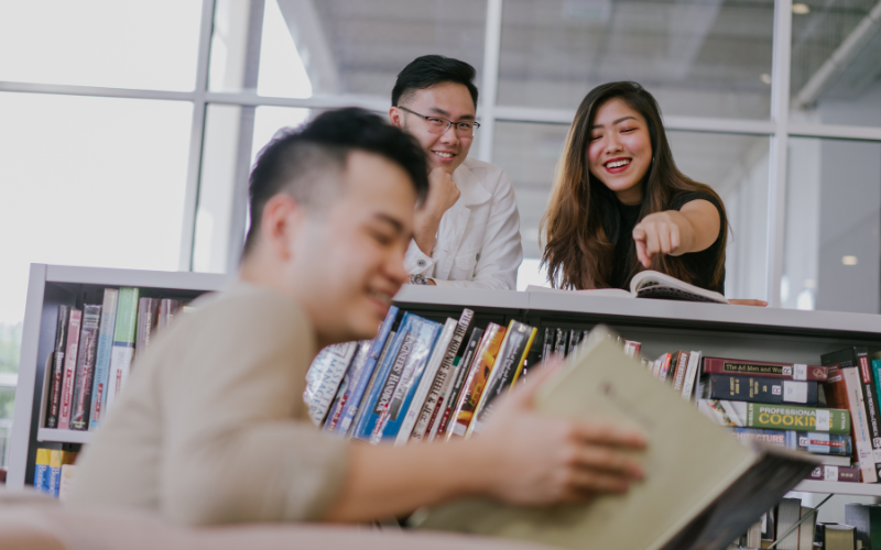 Friends pointing at a book